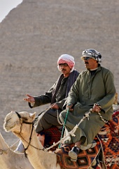 Zwei auf Kamelen vor den Pyramiden  Es sind die Sonnenbrillen, die die Neuzeit verraten. Zwei Araber vor den großen über 2000 Jahre alten Pyramiden bei Kairo.